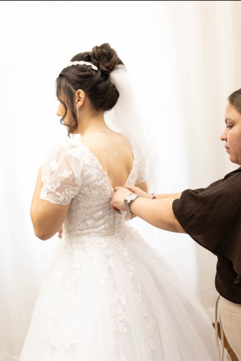 Assessora ajustando o vestido de uma noiva no Belezaria ProvoQ